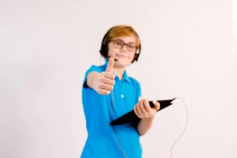 Little boy in glasses using a tablet computer with a light background Stock Photos