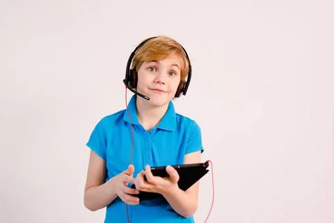 Little boy in glasses using a tablet computer with a light background Stock Photos