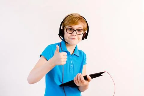 Little boy in glasses using a tablet computer with a light background Stock Photos