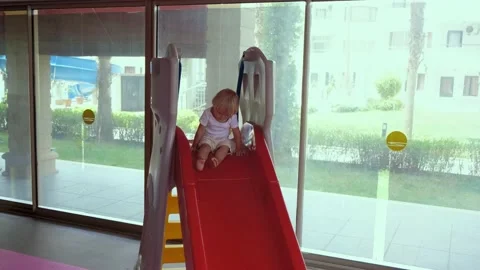 Little boy going down the slide in the playroom Video stock 194683126