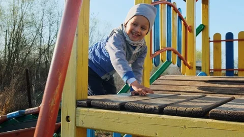 A little boy in a gray cap having a great time in a playground. 動画素材 128438092