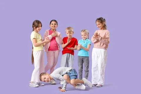 Little boy with group dancing hip-hop on lilac background Stock Photos