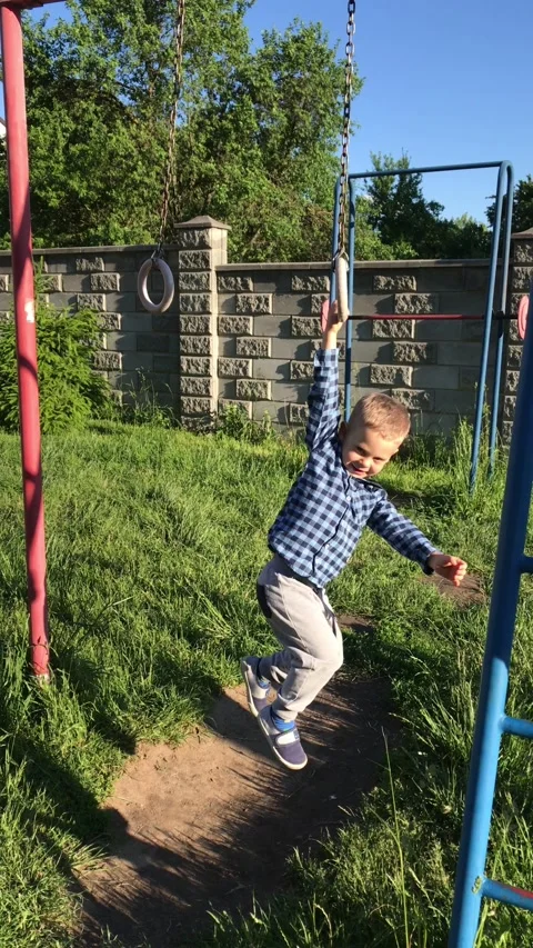 A little boy hangs on a horizontal bar. Stock Footage 196121270