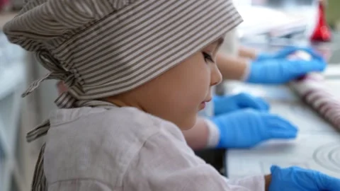 A little boy in a hat and apron makes himself a lollipop made of soft caramel. Stock-Footage 328024914