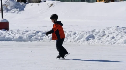 A little boy having fun ice skating on an outdoor skating rink Stock Footage 122989104