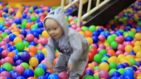 Little boy having fun on the playground with colored balls Video stock 99663752