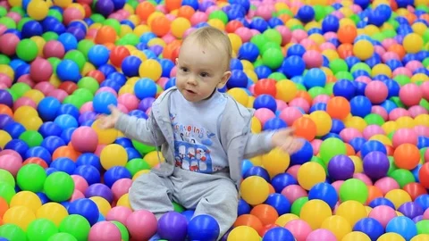 Little boy having fun on the playground with colored balls Stock Footage 99664286