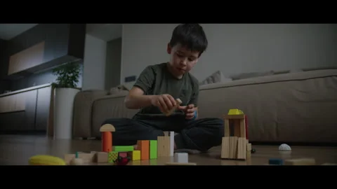 Little boy having fun playing at home with wooden blocks building tower Stock Footage 269350959