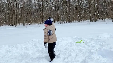 Little boy having fun playing with fresh snow during snowfall. Snowball fight.  Stock Footage 284119694