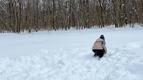 Little boy having fun playing with fresh snow during snowfall. Snowball fight Stock Footage 284119757