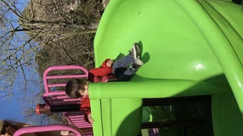 Little boy having fun while sliding on the playground slide. Stock Footage 254536200