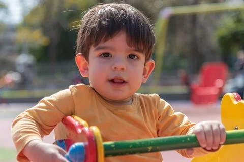 Little boy having fun while playing on the playground in the park. Stock Photos