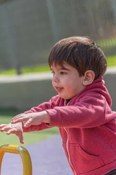 Little boy having fun while enjoying playing in the playground. Stock Photos