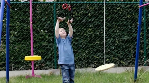 Little boy having good time on swing in the yard Stock Footage
