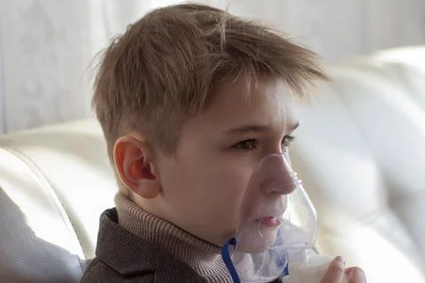 Little boy having inhalation for easing cough. Caucasian blonde boy inhales Stock Photos