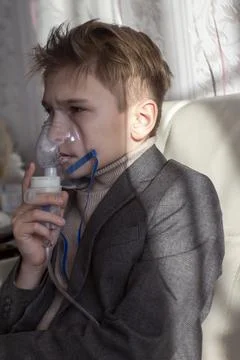 Little boy having inhalation for easing cough. Caucasian blonde boy inhales Stock Photos