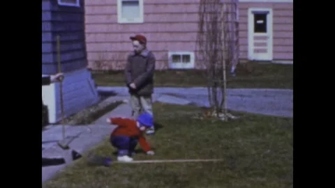 Little boy helping with yard work and playing in the snow in 1968 Stock Footage 326889615