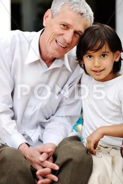 Little boy with his grandfather looking at the camera Stock Photos