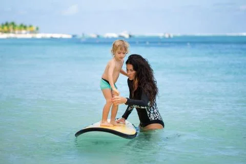 Little boy with his mother learning surfing. Stock Photos