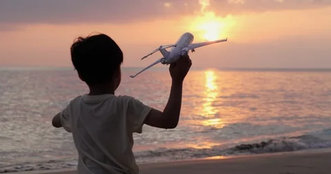 Little boy holding airplane toy and run to the sea. Stock Footage