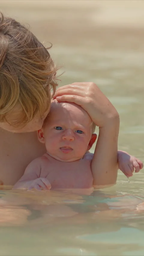 A little boy holds his tiny newborn brother in his hands while sitting in the Stock Footage 310181338