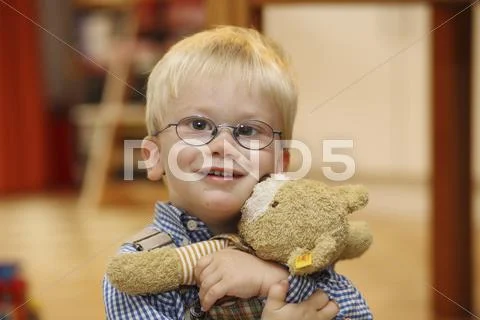 Little boy hugs his teddy bear, strabismus Stock Photos