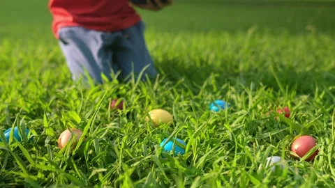 Little boy hunting for egg in spring garden on Easter day Stock Footage 234440794