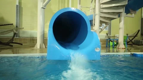 Little boy in inflatable armbands down on plastic water slide in pool Stock Footage 62145706