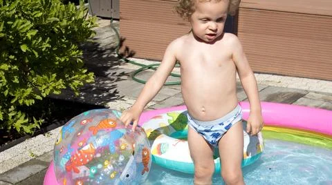Little boy in inflatable pool in summer. Children and water games. Summer Stock Photos