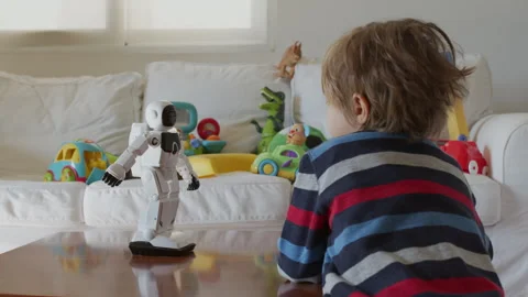 Little boy interacts with robot toy in a bright living room morning Stock Footage 275907852