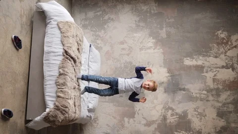 Little boy jumping on a bed Video stock 91822313
