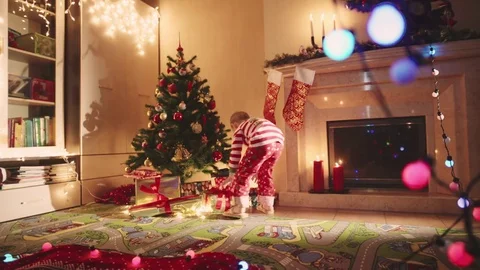 Little boy jumping with gift in his hands on New Years night Stock Footage 72982813