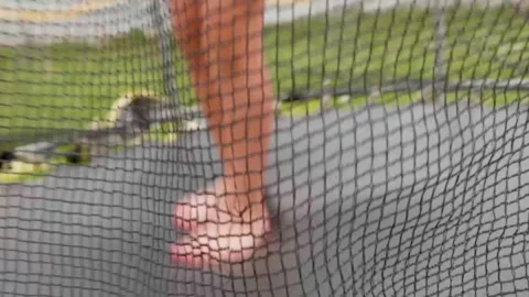 A little boy is jumping on the trampoline behind a protective net Vidéo 285346670