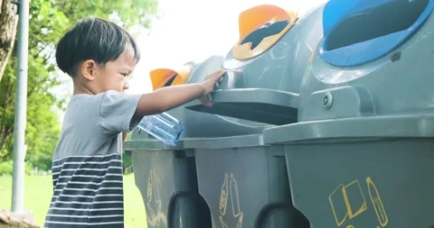 Little boy keep park clean take plastic bottle into trash bin Stock Footage 138784064