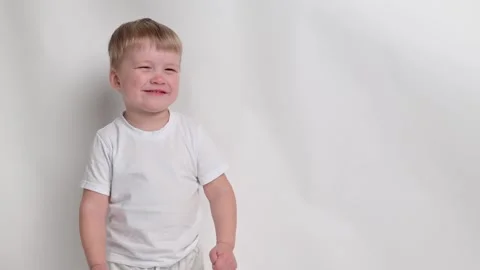 Little boy kid gets angry, hysterics close-up on white background. Concept Stock Footage 242476010