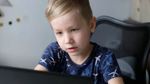 Little boy kid learning or playing on laptop at home, distance education Stock Footage 129354089