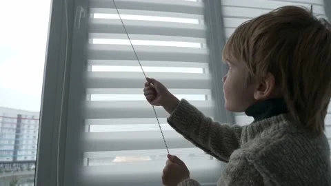 Little Boy Kid Opens Window Roller Shutter Blinds Curtain. Cute Child at Home 4K 库存影片 171769879