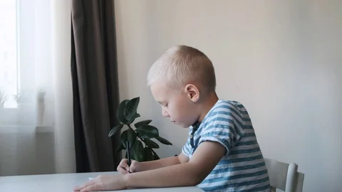 Little boy, kid, sitting at the table at home and drawing, mother kissing and 스톡 동영상 120666337