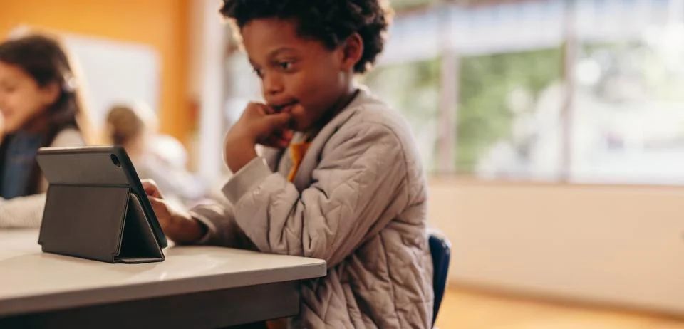 Little boy learning to code using a tablet. Digital literacy in elementary .. Stock Photos