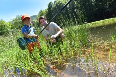 Little boy learning how to fish with his dad Stock Photos