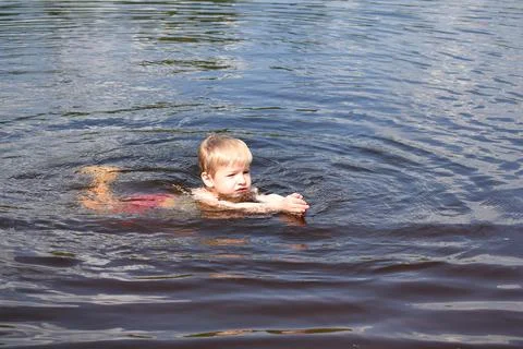 Little boy is learning to swim. Stock Photos