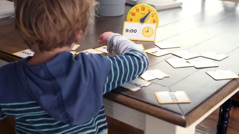 Little Boy Learning Time Using Illustrations And Toy Clock Stock-Footage 129499646