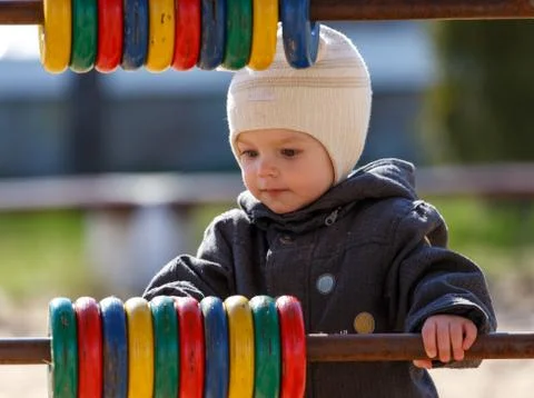 Little boy learns colors by using colored rings on the playground Stock Photos