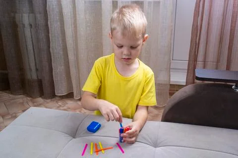 Little boy learns to count with counting sticks Stock Photos