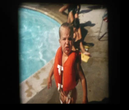 Little boy in life preserver by pool Stock Footage 33844997