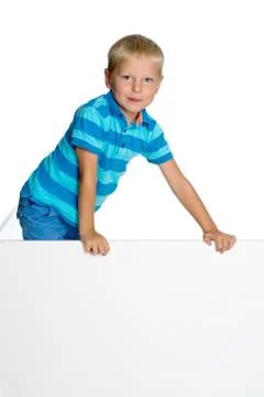 A little boy is looking from behind an empty banner. Stock Photos