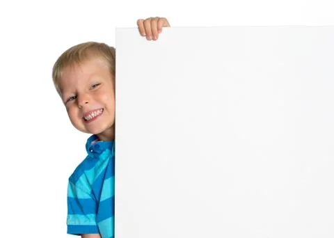 A little boy is looking from behind an empty banner. Stock Photos