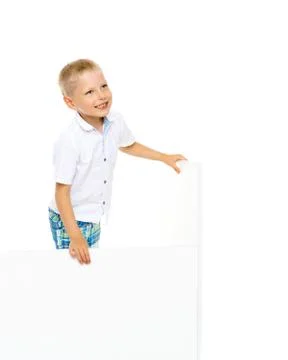 A little boy is looking from behind an empty banner. Stock Photos