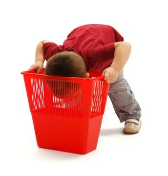 Little boy looking deep into garbage bin Stock Photos