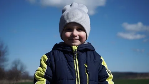 Little boy looks into camera, smiling, portrait of little boy Stock Footage